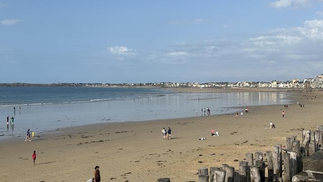 Blick entlang des Sandstrands (Grande Plage du Sillon) von St-Malo. Das Meer ist noch weit draussen und der Strand lädt zum Spaziergang.