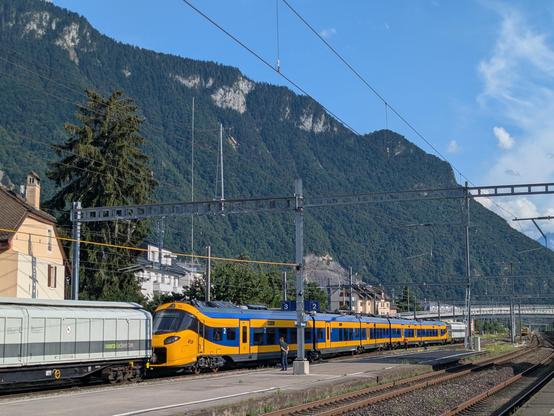 Un ICNG néerlandais flambant neuf sur une voie de garage en gare de Villeneuve VD avec les montagnes en fond d'image.