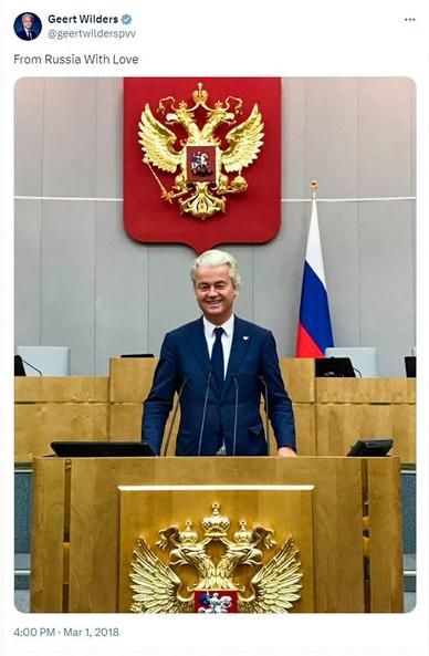 Een screenshot van een tweet van Geert Wilders met de tekst 'From Russia With LOve', met een foto van hemzelf achter het spreekgestoelte van het Russische parlement in Moskou. Op de achtergrond zijn de Russische driekleur en het wapen te zien. Wilders draagt een speldje met de Nederlandse en Russische vlaggen.