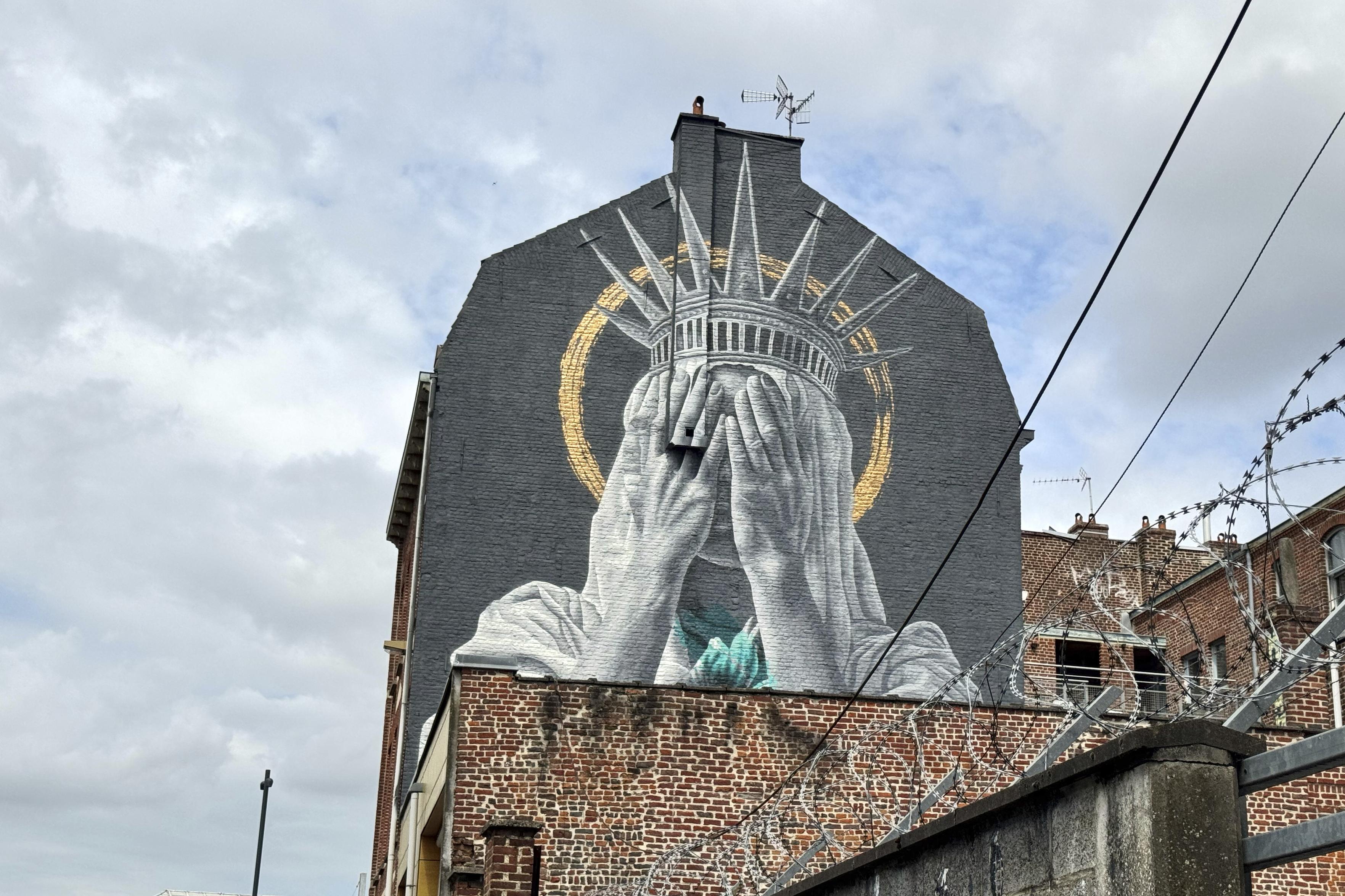 mural of Lady Liberty hiding her face in sadness and shame