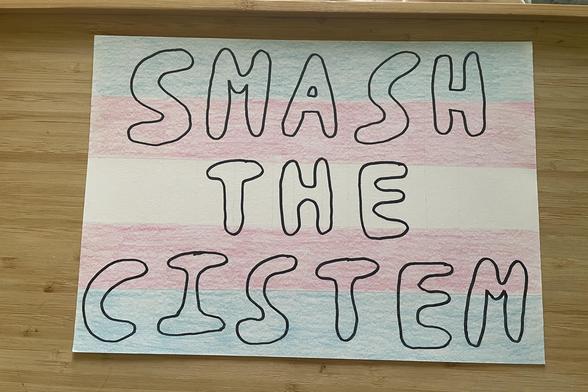 A4 card coloured in as the teams pride flag, with the words SMASH THE CISTEM