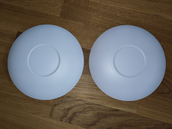 Foto der beiden Access Points, das nach der Reinigung aufgenommen wurde. Beide Gehäuse strahlen weiß.