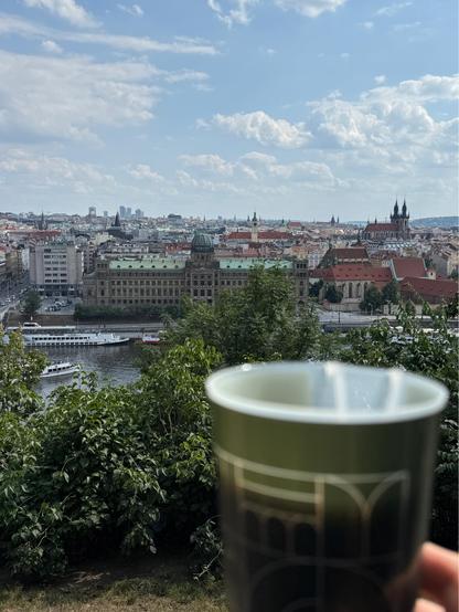 View over Prague from Letnany with a blurry beer in the foreground.
