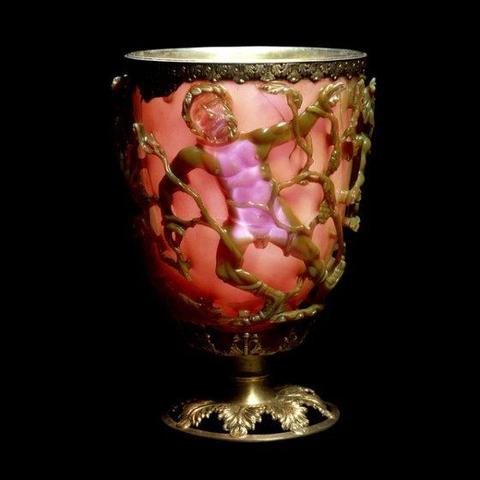 The Lycurgus Cup is a Roman cage cup made of a dichroic glass, which shows a different colour depending on whether or not light is passing through it: red when lit from behind and green when lit from in front. This photo shows it backlit. The cup is a very rare example of a complete Roman cage cup (diatretum), where the glass has been painstakingly cut and ground back to leave only a decorative "cage" at the original surface-level. Many parts of the cage have been completely undercut. The "cage…