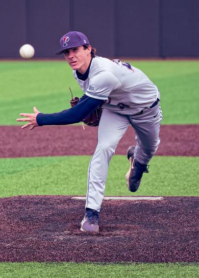 Baseball Pitcher with a P on his billed cap with his rear foot off the ball and the ball seemingly suspended out in front of him