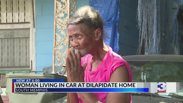 Photograph of 81-year-old Christine Marshall with her palms pressed together speaking to a  news reporter in front of her home on South Parkway in South Memphis, Tennessee. 