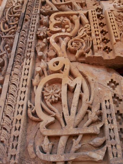 Eng verschlungene Ornamentik aus arabischer Schrift und hinduistischer Pflanzendarstellung. So gesehen in New Delhi in der Anlage des Minaretts Qutab Minar aus dem 13. Jahrhundert.