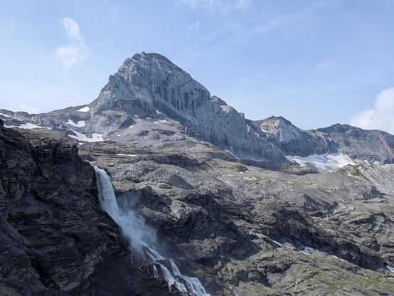 Une cascade et une montagne en forme de dent