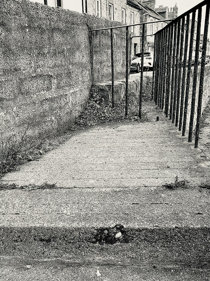 Treppe, die zu einer Mauer führt, seitlich ist ein Gitter. Kein Ausweg.