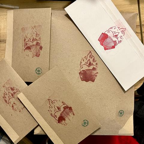 A bunch of packages ready to mail, all with red flamingo accordions stamped in them. 