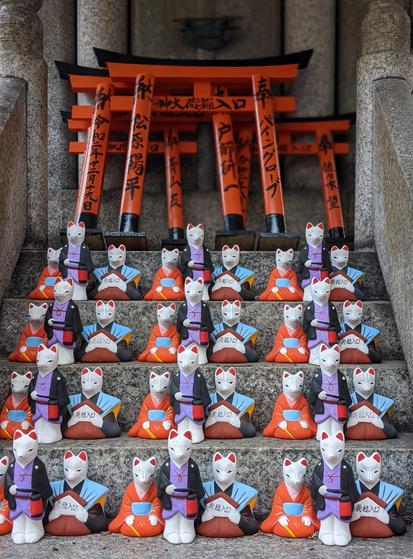 Small ceramic kitsune dressed in kimono are left as offerings (for love and good connections).