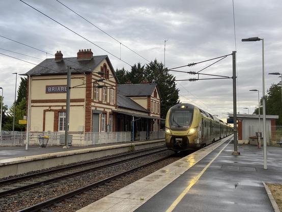 Omneo Premium train Remi Express arriving Briare station under a rainy sky, France