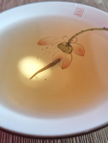 Tea cup with painted lotus inside, play of shadow and light in the tea