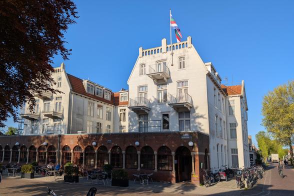 Een wit hotel met eilander vlag tegen blauwe lucht