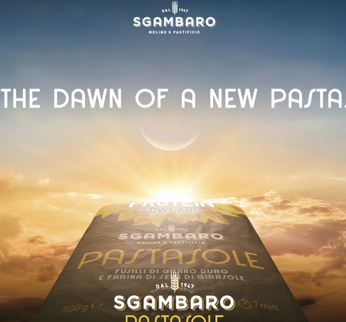  The image features a large package of pasta prominently displayed against a backdrop of a sunrise or sunset sky, with hues of orange and blue blending together. The package is labeled "PASTASOLE" and includes the text "FUSILLI DI GRANO DURO E FARINA DI GIROSAOLE," indicating it is made from hard wheat and sunflower flour. The brand name "SGAMBARO" is visible, along with the year "1947," suggesting a long-standing tradition. The package also mentions "PROTEIN LOWCARB" and "DAL 1947," emphasizin…