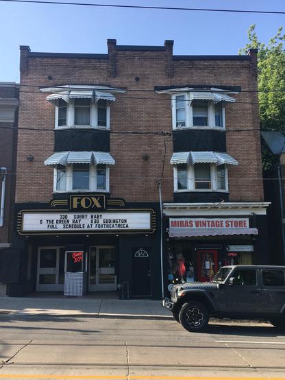 A historic movie theatre featuring a marquee on its facade.