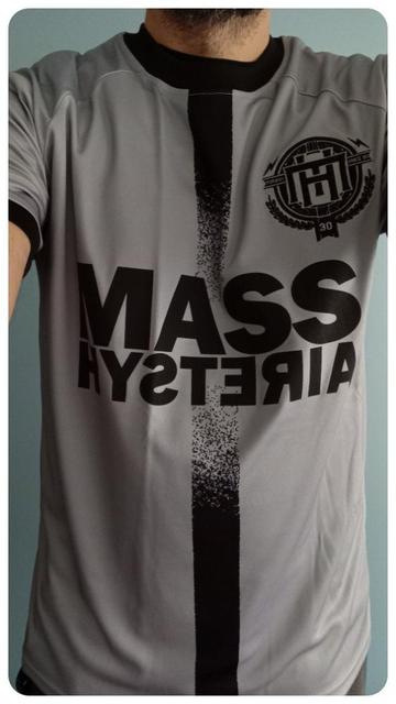 Maillot de foot du groupe Mass Hysteria. 
Acheté le 31/01/2025 au Zénith de Paris. 
De couleur grise avec le nom du groupe au milieu et le logo du groupe brodé en haut à droite. 
Dans le dos on retrouve le nom de l'album Tenace et la date du concert. 
Il est possible que ça ressemble à un maillot d'une autre équipe mais je ne m'y connais pas assez.