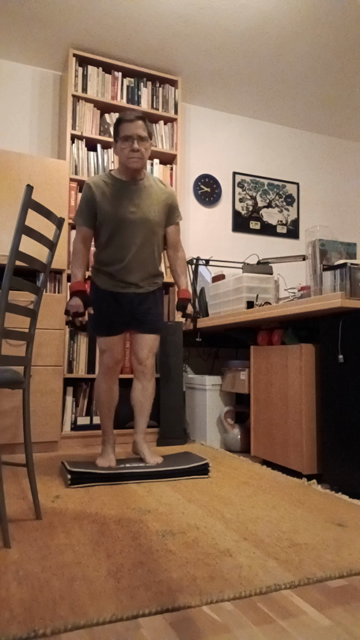 I use the yoga board to get my heels into negative at the bottom for more range of motion. The gloves are ½-kg weighted.