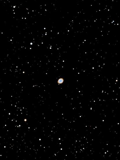 Long-exposure astrophotograph of the Ring Nebula (M57), a glowing donut-shaped planetary nebula in the constellation Lyra. Captured under dark skies at Bubulcus & Bolotas, surrounded by countless stars.