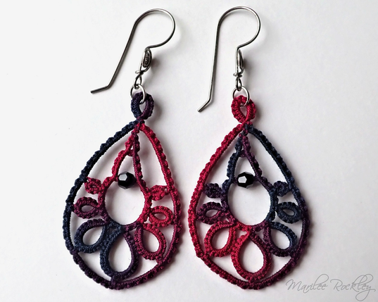 Tatted lace earrings in a teardrop shape with a faceted black crystal bead in the center. The color of the lace shades from red to black. The earwires are handmade from niobium wire.