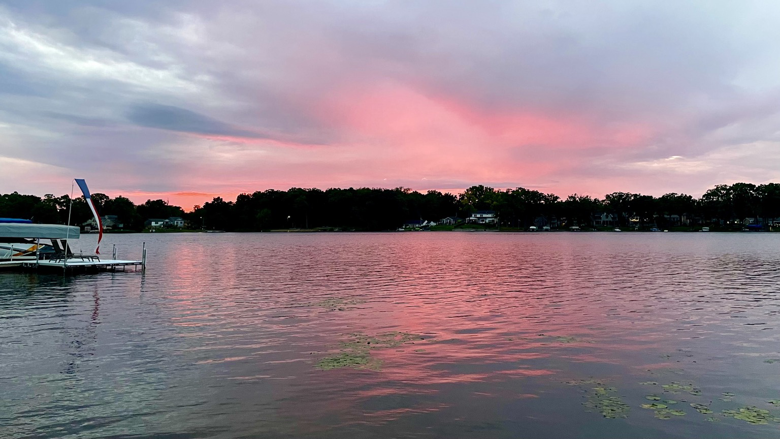 Sunset photo of pink light on the underside of gray clouds reflected in a leak underneath.