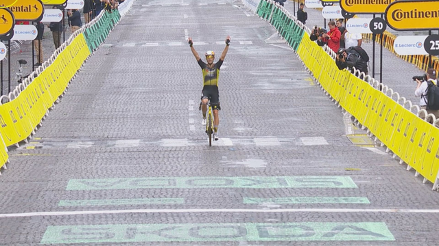 Wout van Aert met twee armen in de lucht over de finishlijn in Parijs