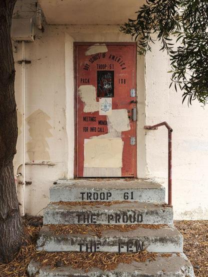Abandoned Boy Scout headquarters. Door reads "Boy Scouts of America, Troop 61, Pack 108." Steps read "Troop 61, The Proud, The Few."