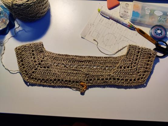 Cardigan de crochet en proceso. Deshice el June top que estaba tejiendo porque no me esta convenciendo el diseño, asi que con el mismo hilo, ando haciendo otro proyecto. En ma imagen se puede ver la parte del cuello y los hombros, anotaciones y material de ganchillo.