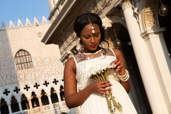 A bride basks in the sun and enjoys her bouquet in St. Mark's Square in Venice, Italy.
