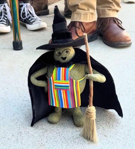 Tiny Chef with his apron cosplays Wicked 's Elphaba with a black cape, a black witches had and a broom at #SDCC. 😭