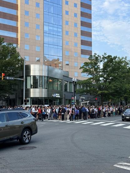 People fill the sidewalk opposite the Clarendon Metro