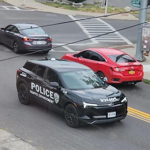 A black Chevy SUV driving in mixed traffic with the words "police traffic enforcement" on the side
