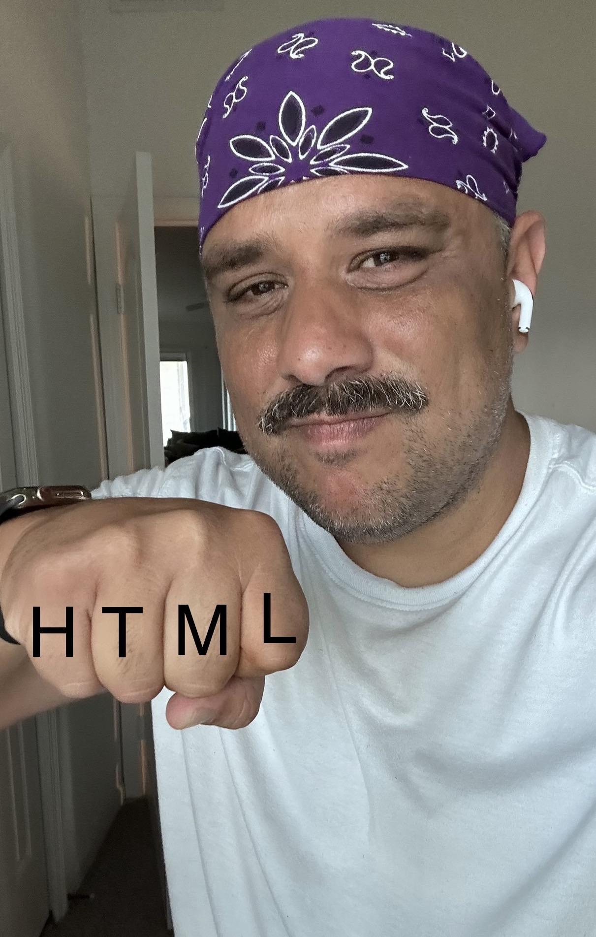 Me making a fist with the letters "HTML" displayed prominently on the image. Im wearing a purple bandana and white shirt, with earbuds visible. The background is an interior space with a door and window.