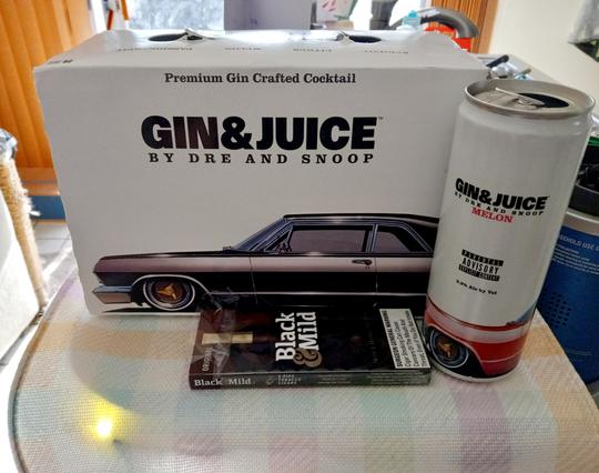 A picture of a box of Dr Dre and Snoop's Gin and Juice, premium gin crafted cocktail. Next to the carton is one of the cans, Melon, with a parental advisory explicit content.

Other flavors included in this variety pack

Apricot 
Citrus
Passionfruit 

Next to the box and can is a 5 pack of Black and Mild cigars, taste and aroma since 1856.