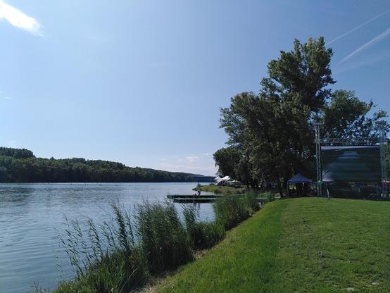 zaber na cast trate na Zemniku, priestor pre divakov s velkorozmernou obrazovkou, v pozadi most dialnicneho obchvatu
