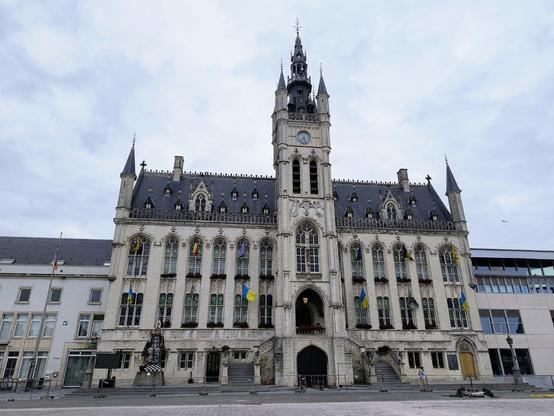 Auf dem Bild: Das #Rathaus von Sint-Niklaas, erhebt sich majestätisch auf dem Grote Markt. Das Gebäude ist im neugotischen Stil errichtet und hat einen großen Turm.mit Uhr in der Mitte als Eingangsportal, an den Giebelsritdn befindet dich jeweils noch ein kleinerer Rundturm, der aus den Hausecken herausragt.