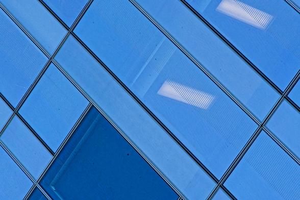 A mondrian-like pattern of diagonal lines at 90 degrees to each other with panels of various shades of blue and two rectangular lights obscured by rows of fine lines.