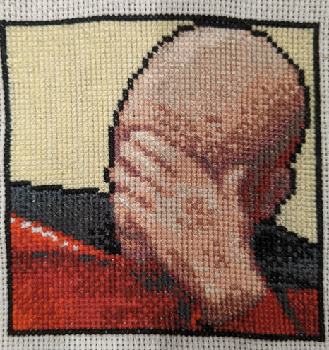 Cross stitch embroidery of Picard from Star Trek with his hand on his face