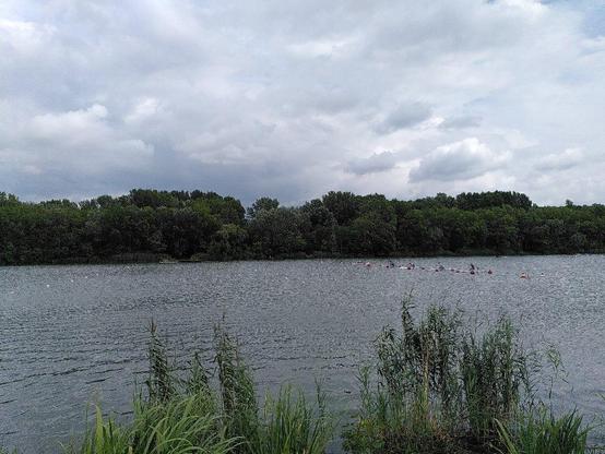 zaber na Zamnik, prave startuju muzi C1 na 200m

v popredi trstie, na vode kanoisti v stsrtovacich boxoch, v pozadi stromy a oblacna obloha