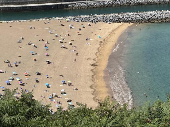Vista aérea de playa salpicada de sombrillas coloridas