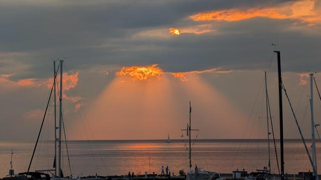 Clouds and sunset over the calm water of Green Bay. Boats tied up at Egg Harbor Marina are in the foreground.