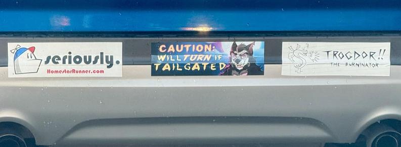 Three bumper stickers on a car:

“Seriously” homestarrunner.com

“Caution: will turn if tailgated”

“Trogdor!! The Burninator