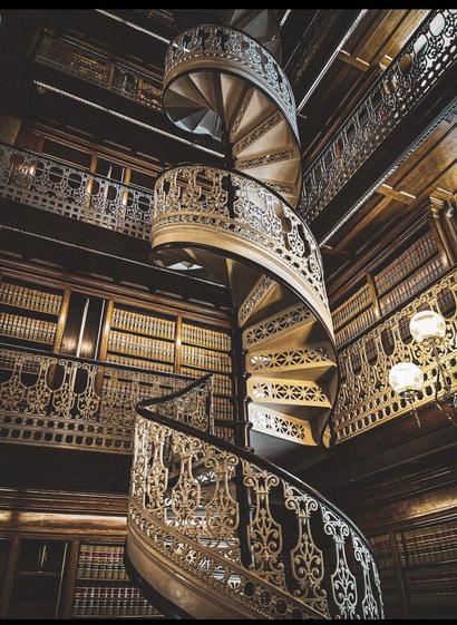 Beautiful wrought iron spiral staircase in a library. It connects 5 storeys of books.