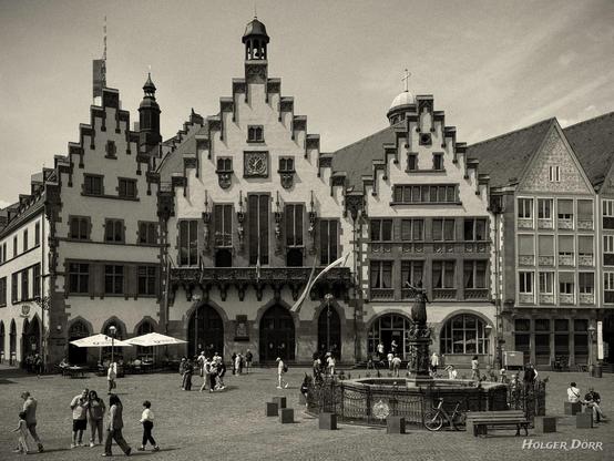 Historisches Rathaus „Römer“ in Frankfurt am Main, aufgenommen in sepiafarbener Tönung. Die markante Treppengiebelfassade und der mittelalterliche Platz mit Menschen und Brunnen verleihen dem Bild eine zeitlose, nostalgische Atmosphäre.