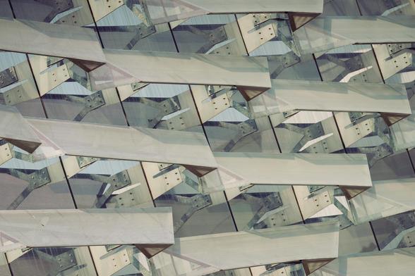 An Array of perforated metal panels over glass windows form the outermost skin of an academic building.