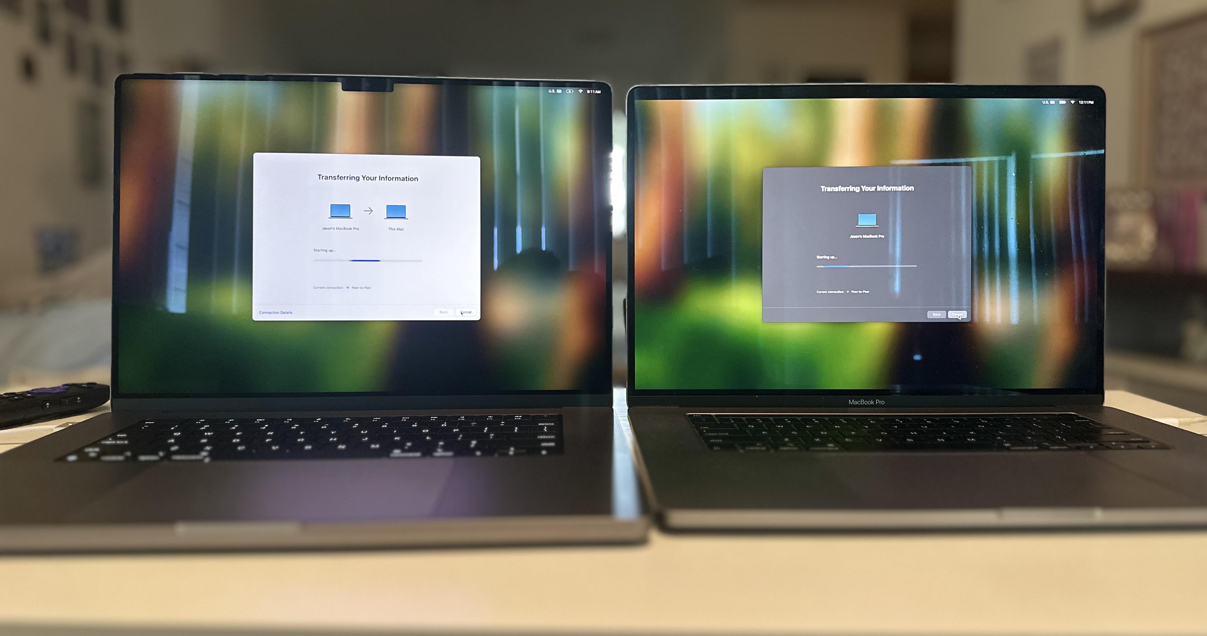 Two laptops side by side on a white table. Screens show a transfer of info.  Left side: new MacBook Pro 16in M1 Right side: old MacBook Pro 16in i9 Intel 