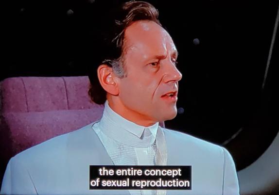 Star Trek The Next Generation scene. Three screenshots. In the first two, we see a human guy in a fancy white coat and stuffy formal collar sitting in the conference room talking. He has his nose turned up and seems hoighty-toighty. Closed caption reads, "The entire concept of sexual reproductive is a little repugnant to us." Next screenshot is a cut to Will Riker, in opposite chair across the table leaning back but now slightly forward and looking intense and offended in response. His eyes are simultaneously smouldering, angry, and disappointed. 