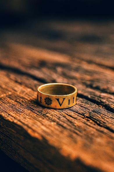 Gravierter Ring auf altem Holzbrett.