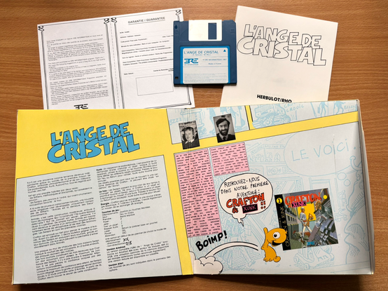 Warranty card, floppy disk, novel, and inside cover of the game L'Ange de Cristal. The story and game instructions are on the left side. On the right are biographies of the two creators: Rémi Herbulot (code) and Michel Rho (art and graphics).