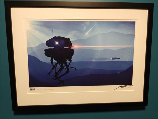 Eit innramma kunsttrykk på ein blå vegg. Motivet er ei skummel drone som skyt laser. Bakgrunnen er eit blåleg vinterlandskap (Finse, Noreg), og vi ser ein Snowspeeder i horisonten.